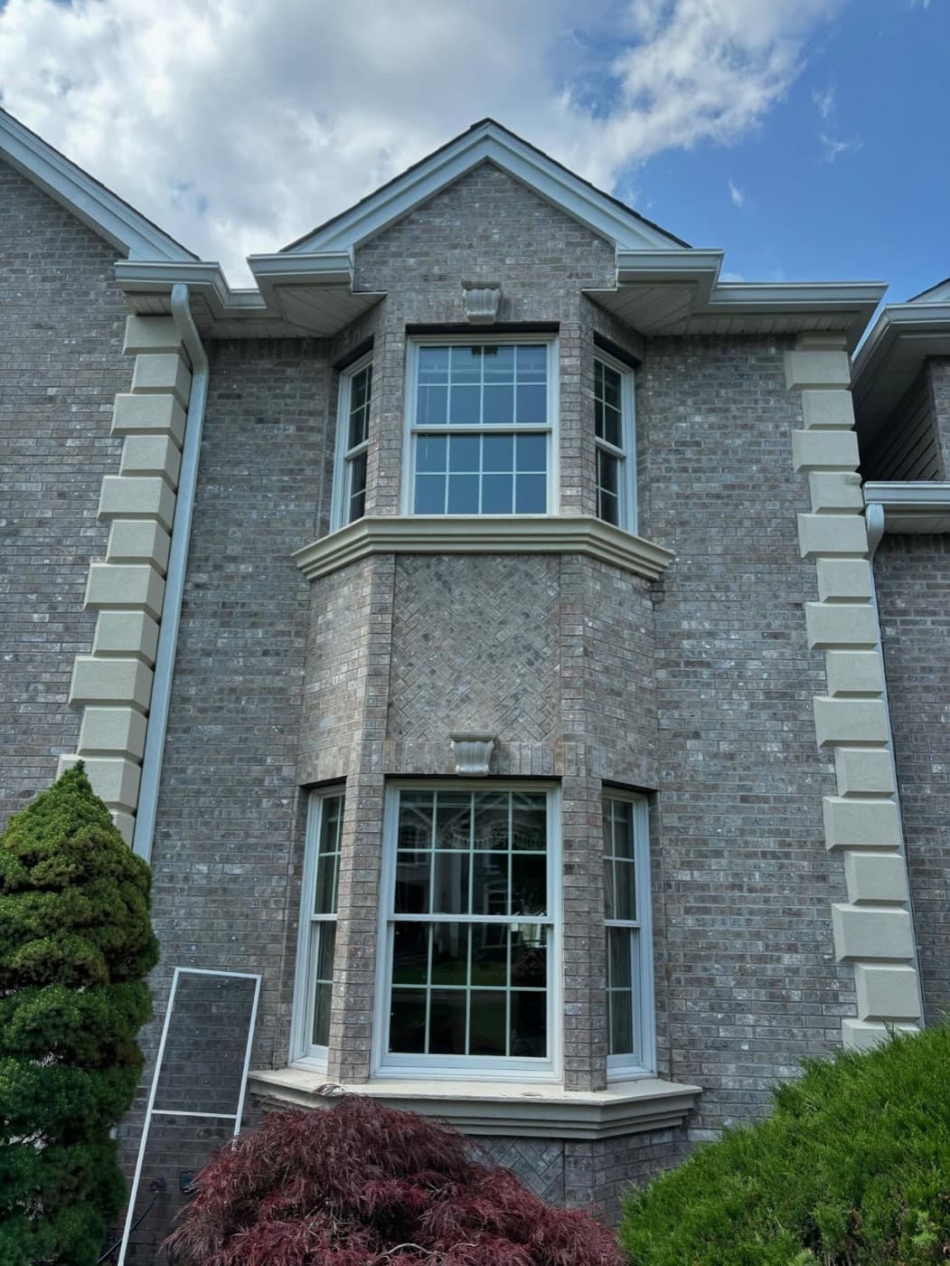 Gray stone home with tall corner windows and spotless glass