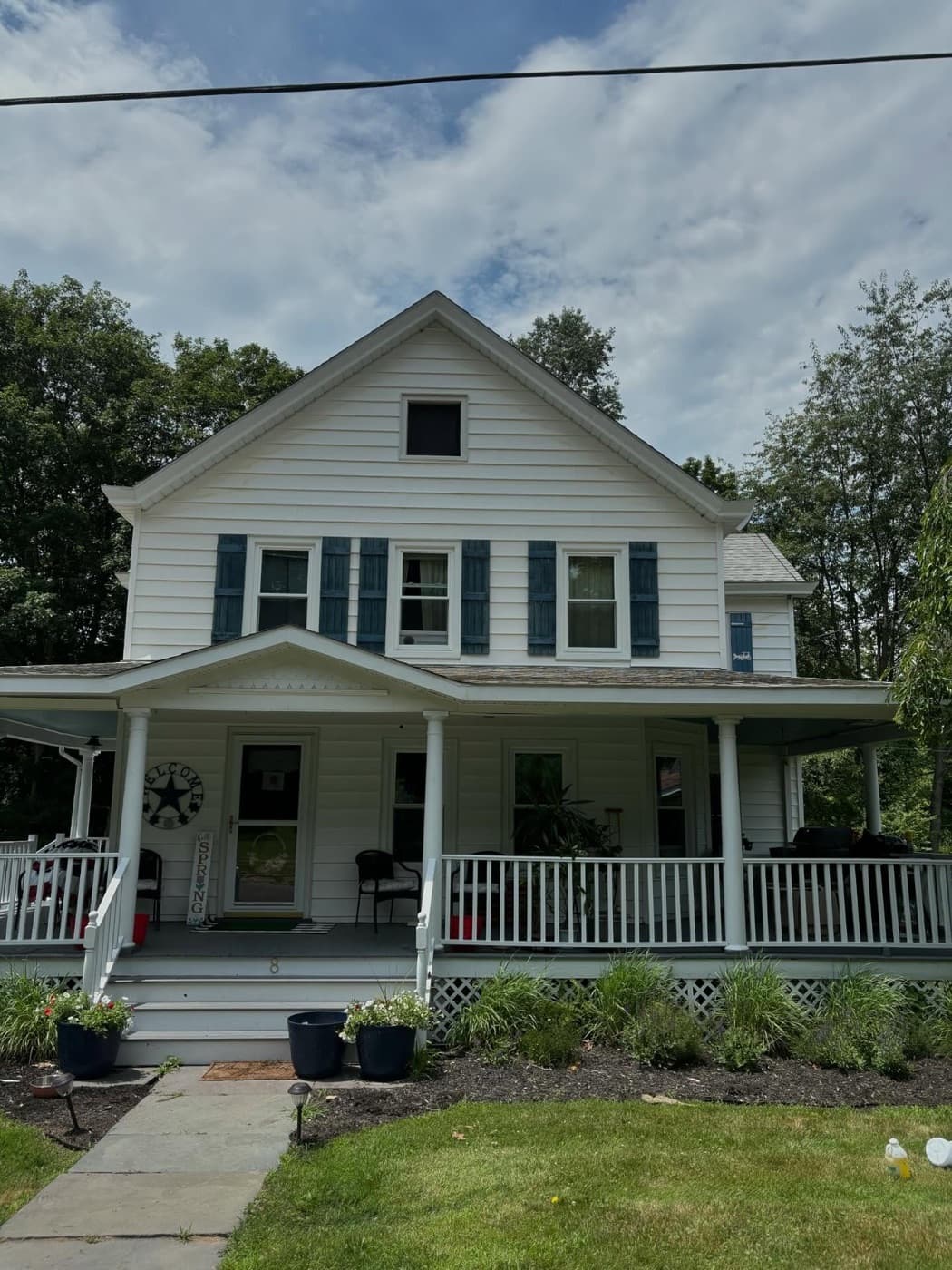 White farmhouse with a covered porch after window cleaning