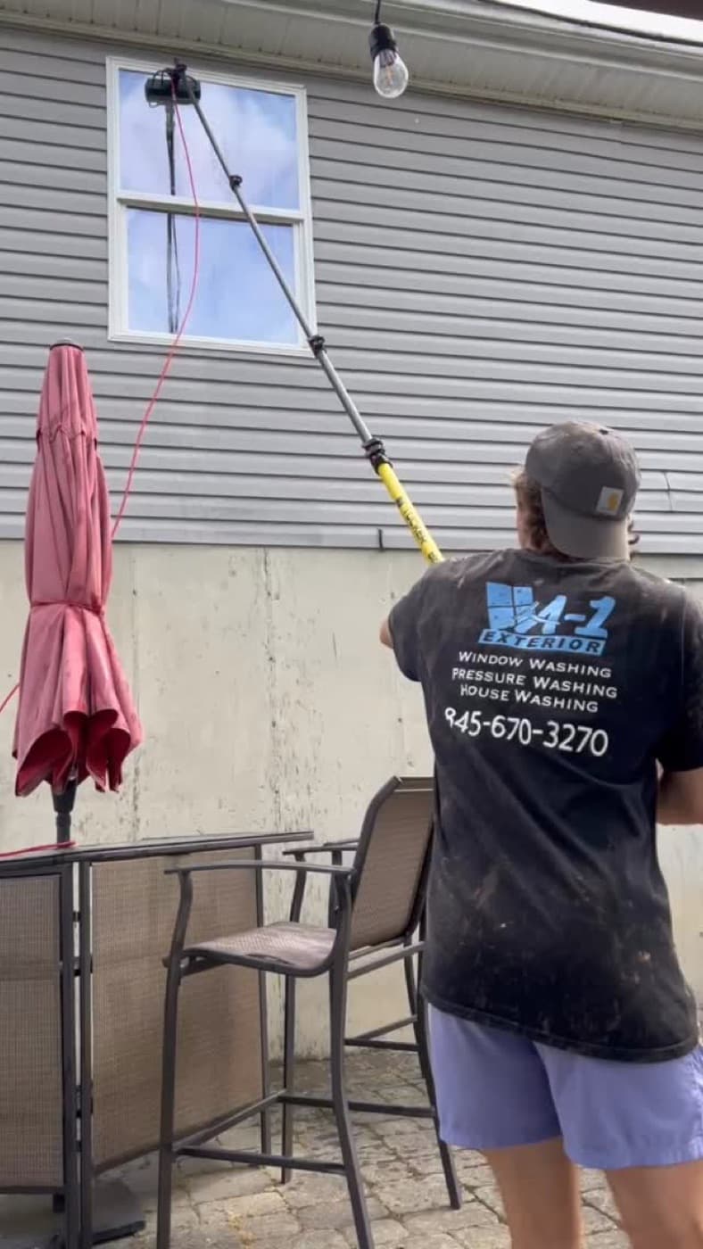 Anthony cleaning glass in his A-1 Exterior shirt, phone number on the back